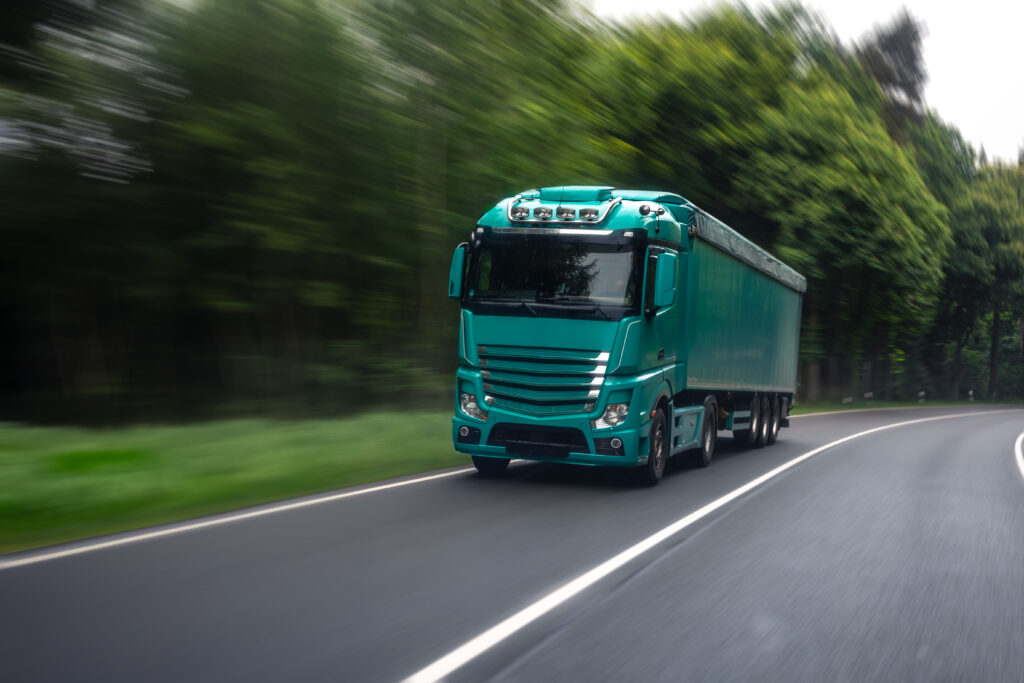 truck on forest road. moving lorry. freight transport scene.